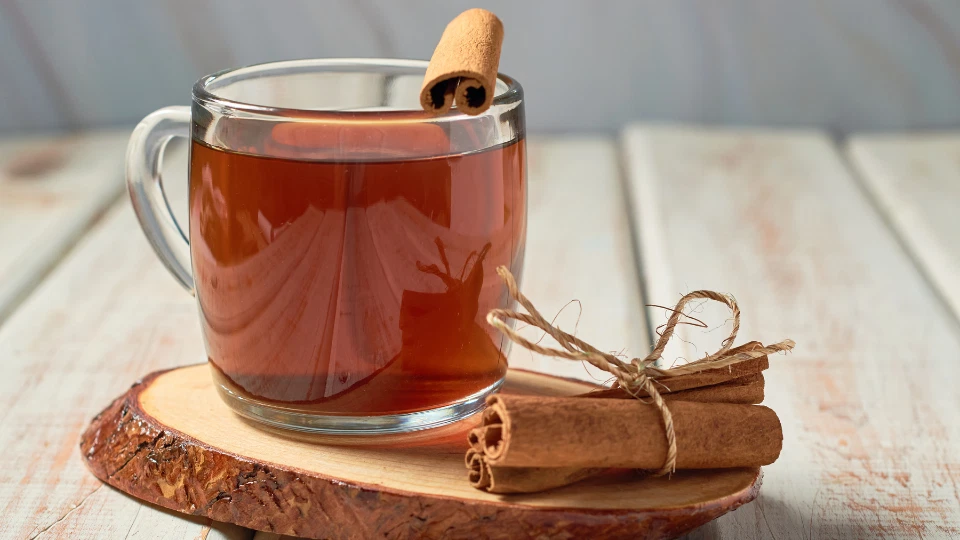 A warm drink with cinnamon on a kitchen table, representing a simple daily habit for well-being